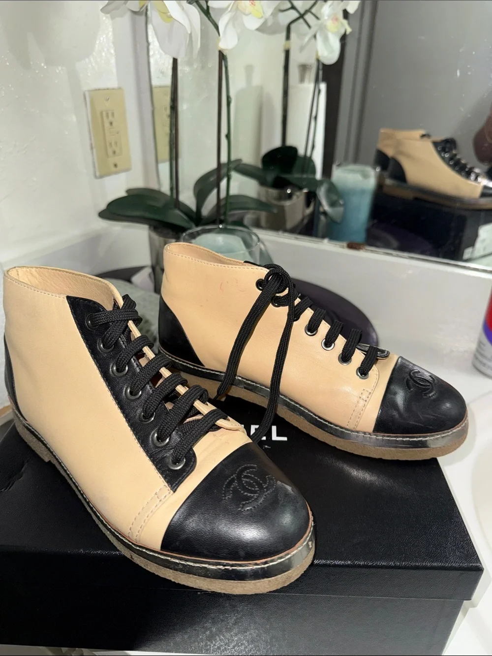 CHANEL Two-Tone Leather High-Top Sneakers in Beige & Black